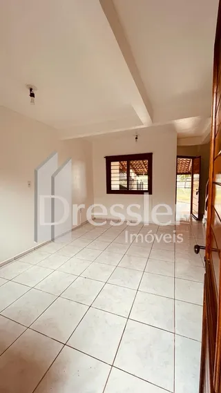 Interior de uma sala com piso de cerâmica clara e paredes brancas.