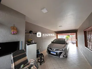 Foto interna de uma sala com piso de cerâmica e um veículo estacionado no fundo.