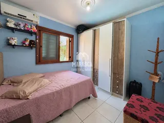 Quarto com cama e armários em um apartamento na Lajeado.
