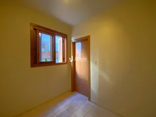 Vista interna de um ambiente com parede amarela e piso de cerâmica.