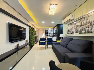 Sala de estar moderna com sofá e televisão em um apartamento.