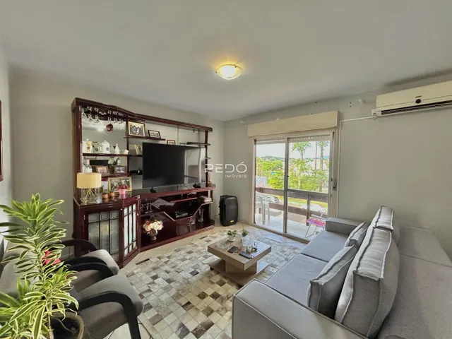 Sala de estar com sofá e móveis de madeira em um imóvel no Brasil.