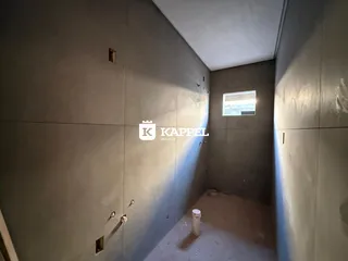 Foto de um corredor interno com paredes lisas e piso cru.