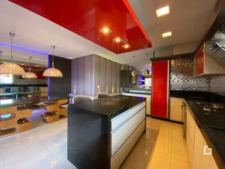 Cozinha moderna com ilha e armários em tons de branco e preto.