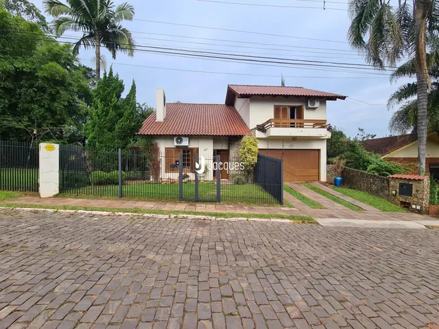 Fachada de uma casa em Lajeado, Brasil, com cerca e garagem.
