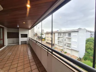 Vista da varanda com piso de cerâmica e teto de madeira.
