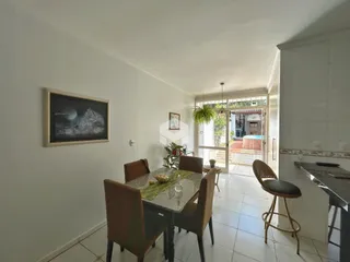 Foto de uma sala de jantar com mesa de madeira e cadeiras em um imóvel no Brasil.