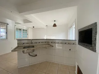 Vista de uma cozinha moderna com armários brancos e piso claro.