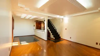 Hall de entrada com piso de madeira e escadaria.