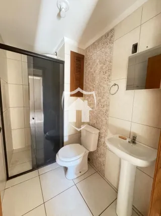 Foto de um banheiro com piso de cerâmica e louças brancas.