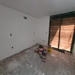 Foto de um cômodo interno vazio com piso de concreto.