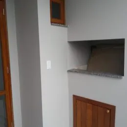 Detalhe de uma parede interna branca com uma prateleira embutida.