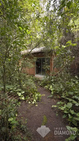 Fachada de uma residência em Lajeado, Brasil, cercada por vegetação densa.