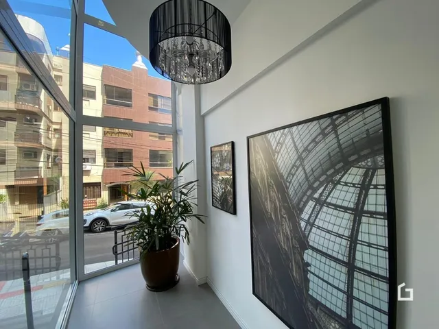 Vista da sala de estar com grandes janelas de vidro.