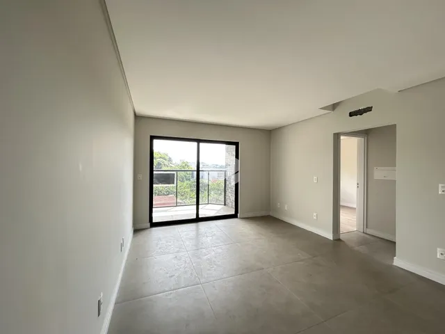 Sala de estar ampla com porta de vidro que dá acesso ao exterior.