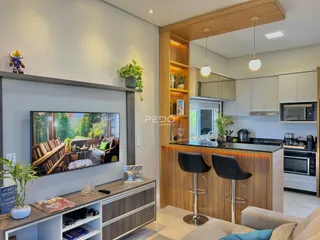 Sala de estar com decoração moderna e cozinha integrada em Lajeado.