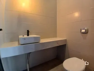 Foto de um banheiro moderno com bancada e vaso sanitário.