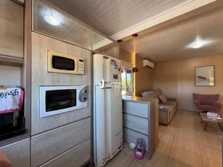 Imagem interna de uma sala de estar com cozinha em um imóvel em Lajeado, Brasil.