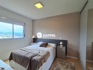 Quarto com cama e janela mostrando uma vista da paisagem.