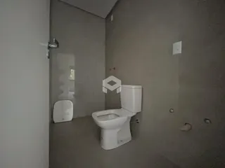 Corredor interno mostrando um banheiro com vaso sanitário branco.