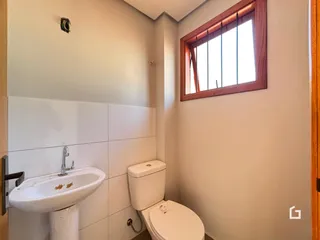 Foto de um banheiro com azulejos brancos e janela de madeira.