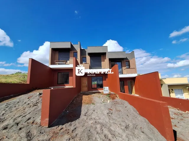 Fachada de uma casa moderna em Lajeado, Brasil, com muro de contenção de terra.