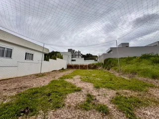 Foto da fachada de uma residência branca com área gramada no terreno em Lajeado.