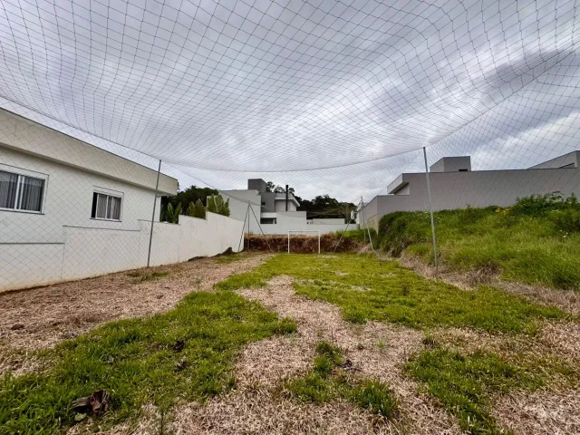 Foto da fachada de uma residência branca com área gramada no terreno em Lajeado.