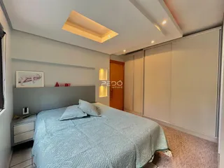 Quarto com cama e armários em um apartamento moderno.
