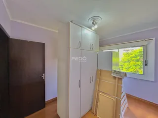 Interior de um cômodo com armários brancos e janela.