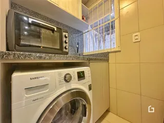 Foto de uma área interna mostrando eletrodomésticos e revestimentos de uma residência.