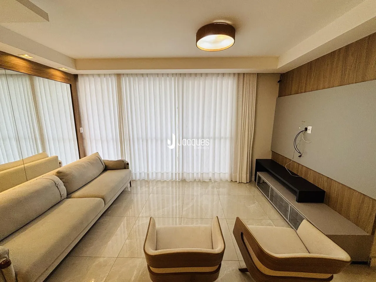 Sala de estar com sofá e piso de porcelanato claro.