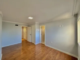 Hall de entrada com piso de madeira e portas abertas.