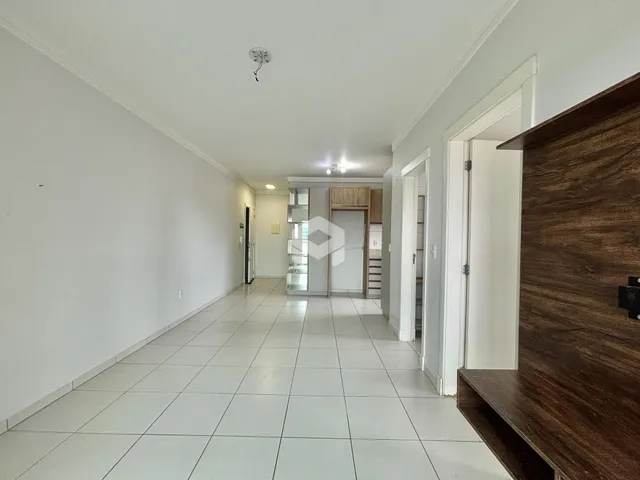 Corredor interno de uma residência com piso de cerâmica clara.