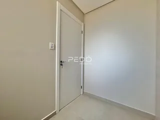 Hall de entrada com porta branca e piso claro.