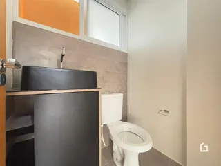 Foto de um banheiro com azulejos e vaso sanitário.