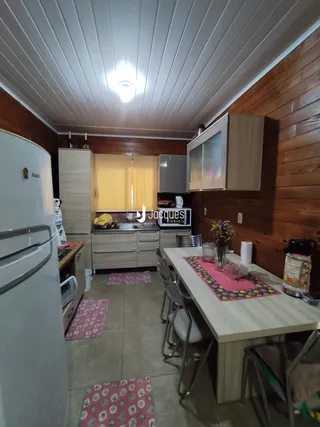 Foto da cozinha e sala de jantar com armários e mesa de jantar em uma residência.