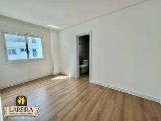 Ambiente interno com piso de madeira clara e janela.