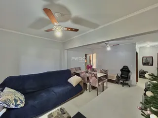 Sala de estar com sofá azul e mesa de jantar em imóvel no Brasil.