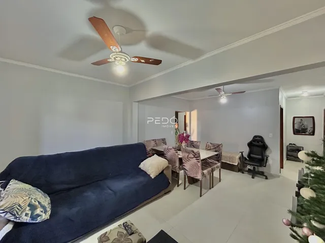 Sala de estar com sofá azul e mesa de jantar em imóvel no Brasil.