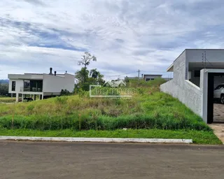Fachada de uma residência branca com gramado em primeiro plano.