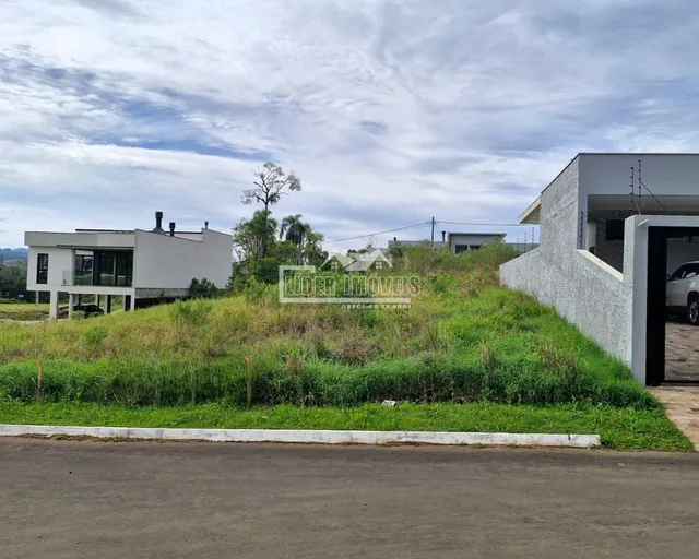 Fachada de uma residência branca com gramado em primeiro plano.