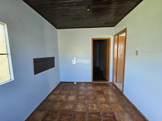 Espaço interno com piso de cerâmica e paredes brancas.