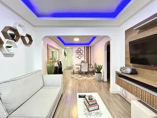Sala de estar moderna com piso de madeira e sofá branco.