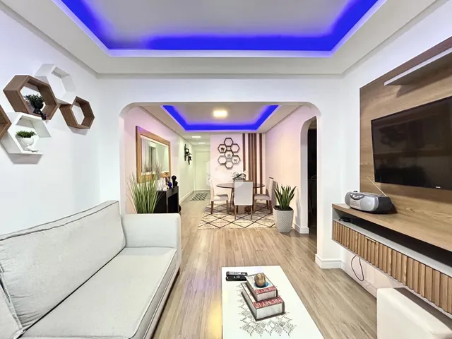 Sala de estar moderna com piso de madeira e sofá branco.