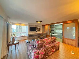 Sala de estar com piso de madeira e sofá decorado em Lajeado, Brasil.