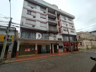 Fachada de um prédio residencial e comercial na rua.
