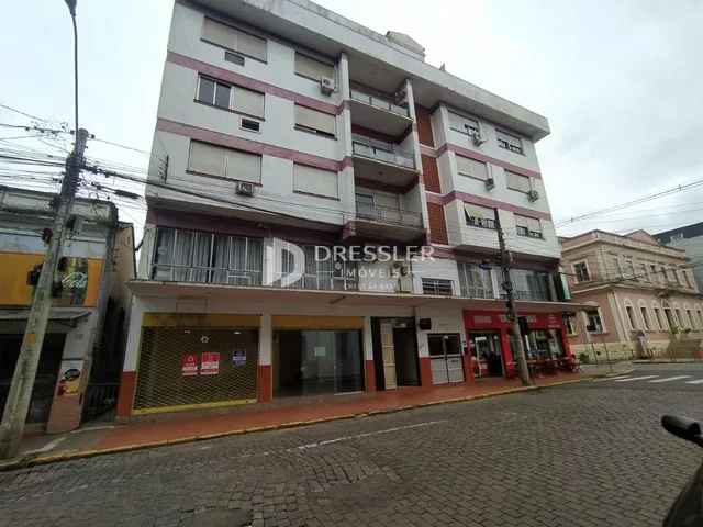 Fachada de um prédio residencial e comercial na rua.