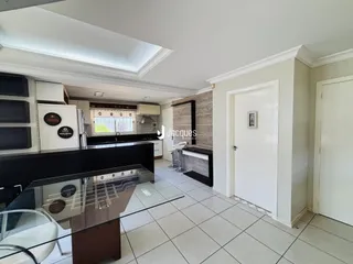 Vista da cozinha moderna com ilha e piso cerâmico.