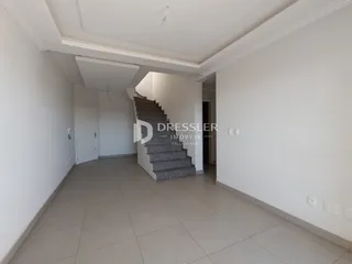 Corredor interno com escadaria e piso claro.